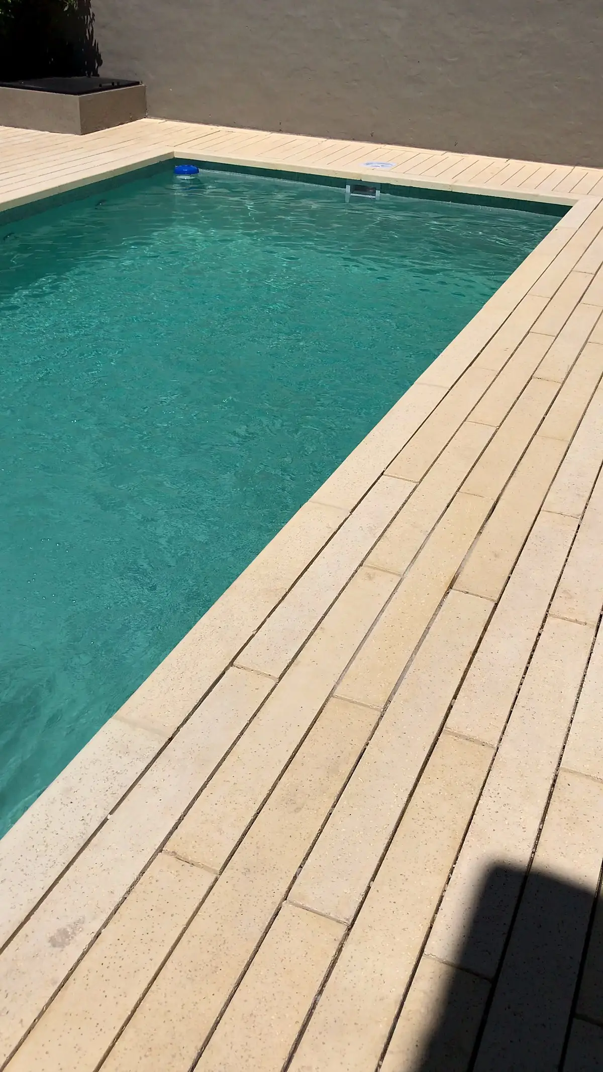 Solárium de placas atérmicas símil madera junto a la piscina