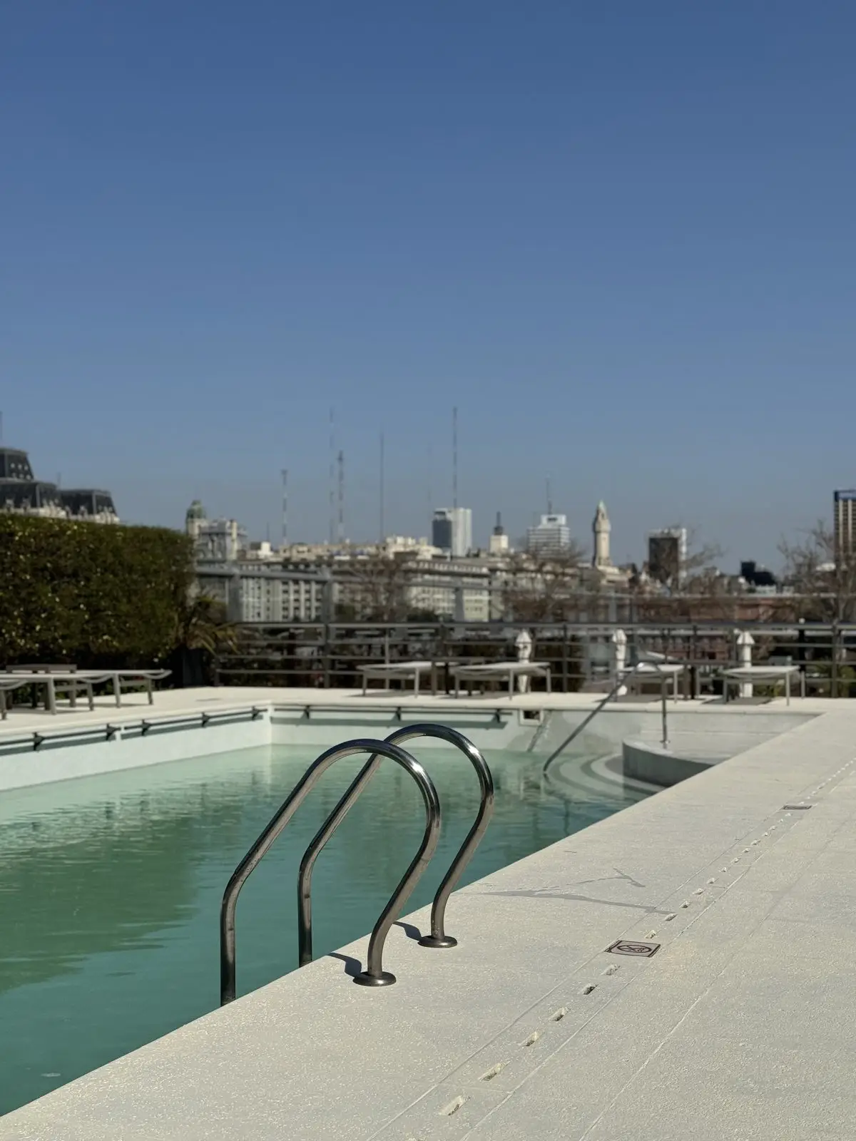 Escalera de acero de la piscina renovada, con vista a la ciudad de Buenos Aires