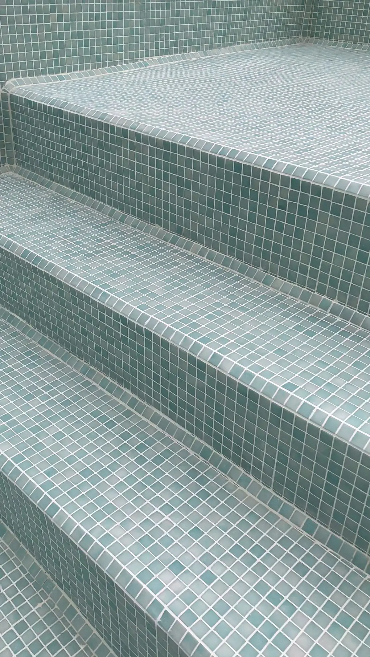 Escalones de la piscina revestidos con venecitas verde agua