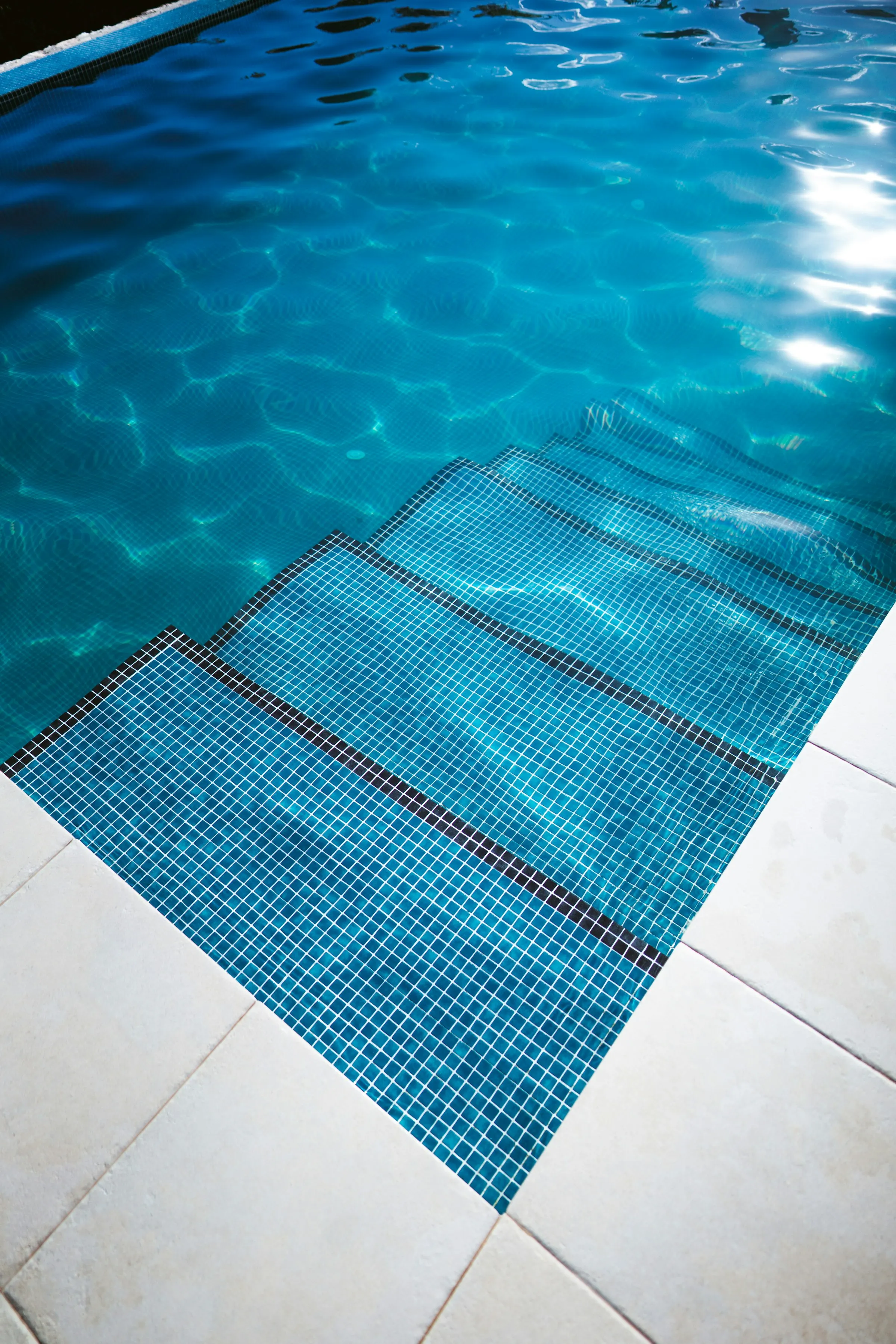 Escalones de piscina revestidos con venecitas nuevas
