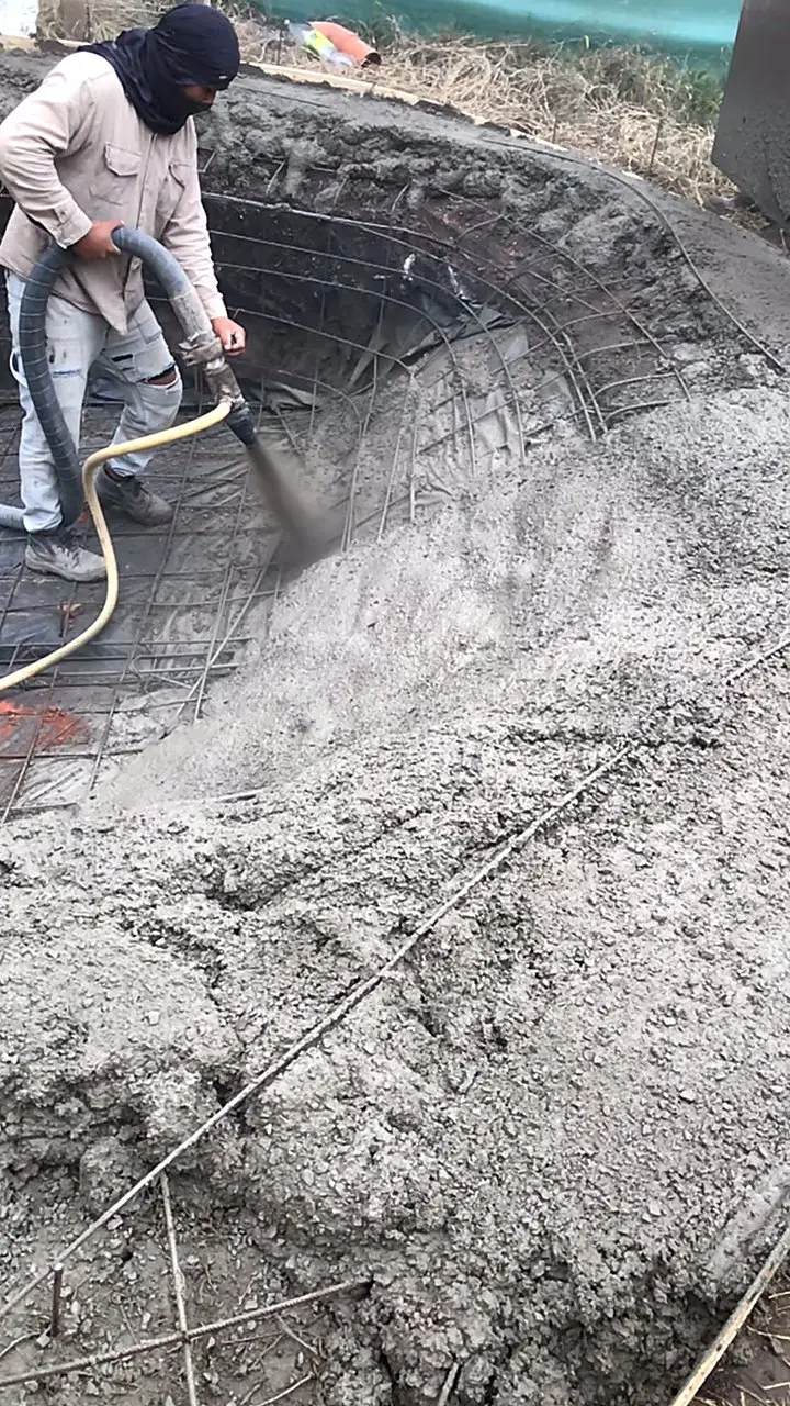 Hormigón proyectado a presión sobre la armadura curva de la piscina