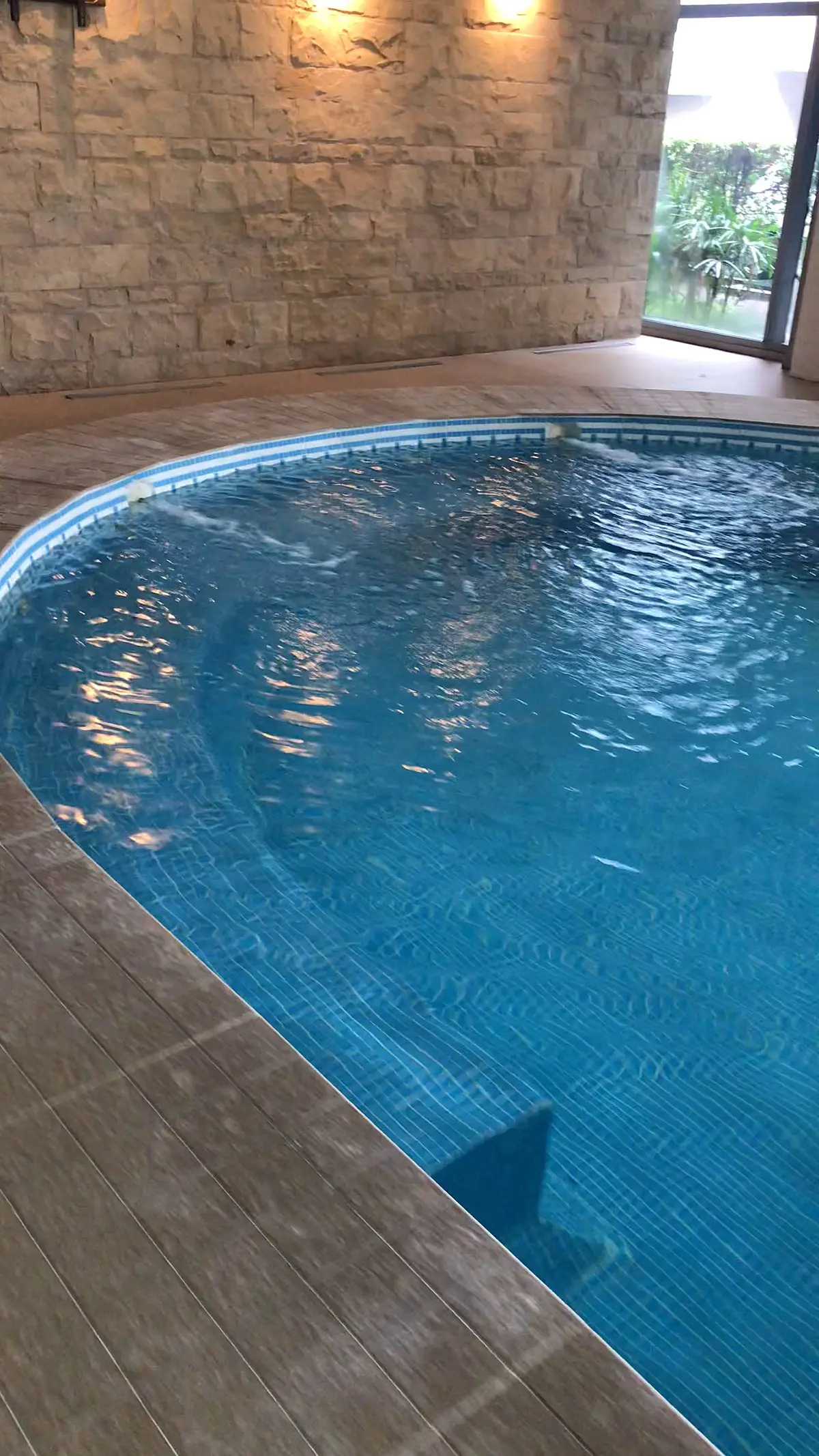 Extremo curvo de la piscina cubierta con el revestimiento nuevo