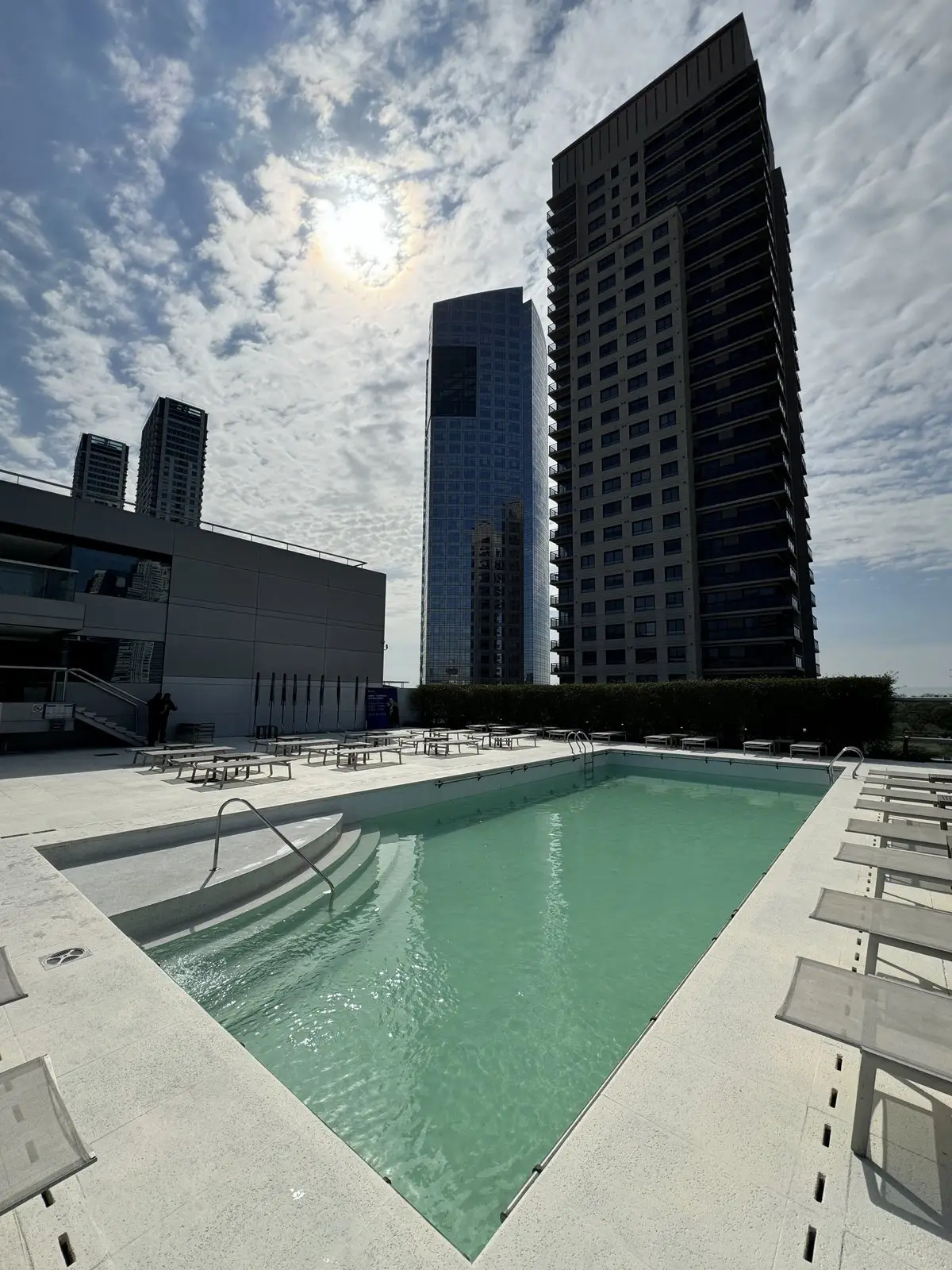 Piscina del hotel Hilton terminada, con agua turquesa y las torres de Puerto Madero detrás