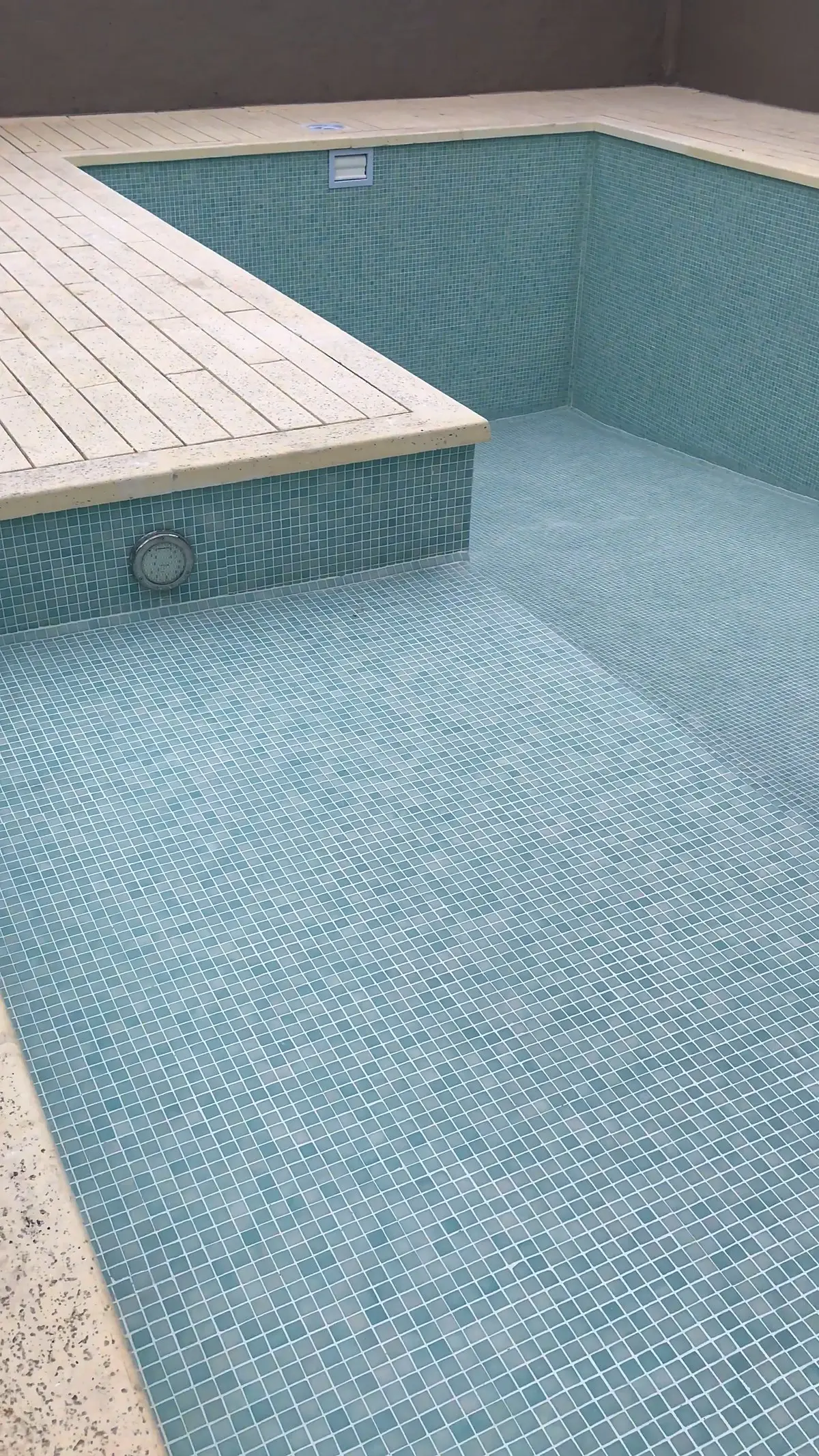 Piscina revestida antes del llenado, con banco y luz subacuática