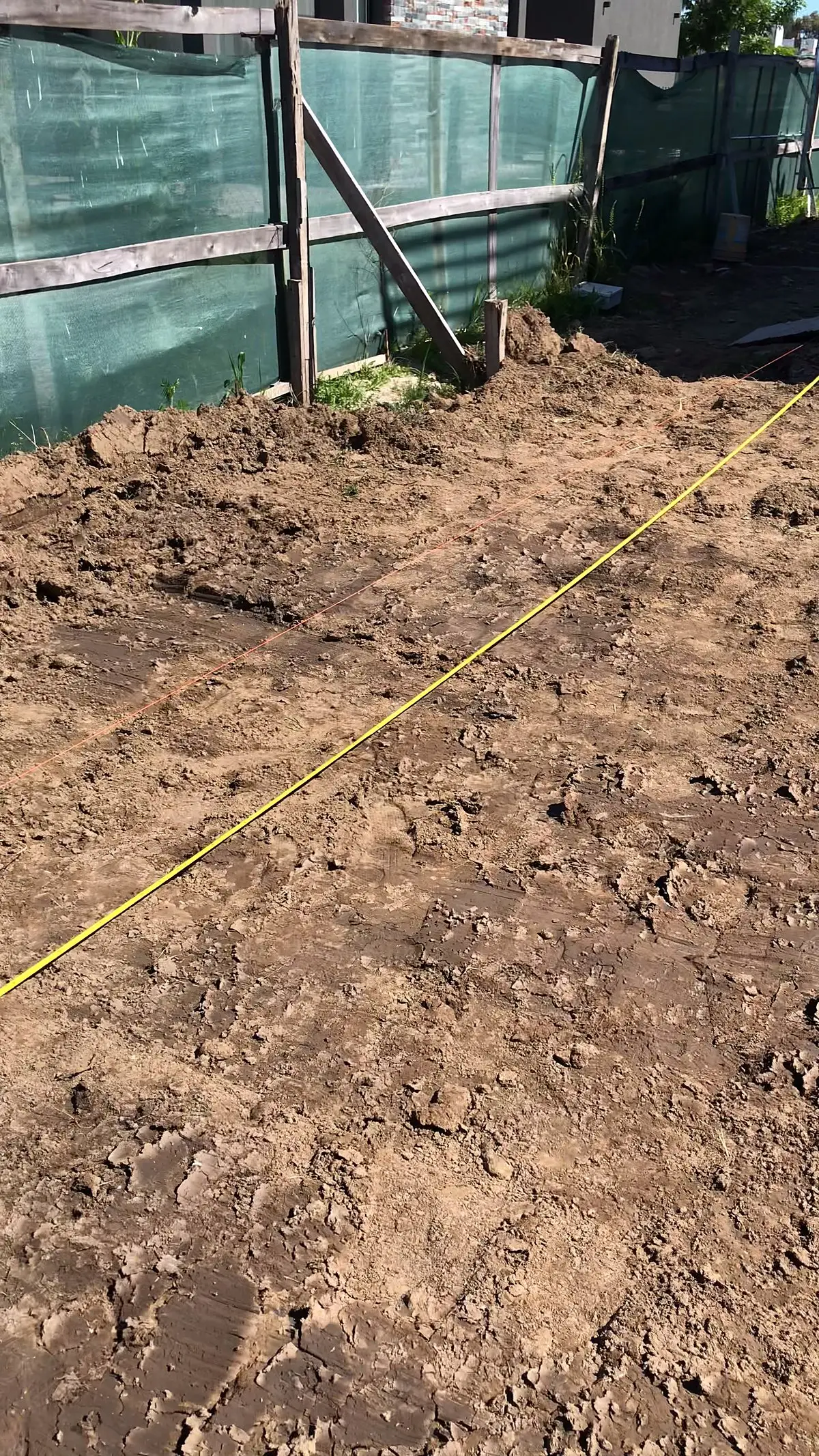 Replanteo de la piscina en el terreno con hilos y estacas